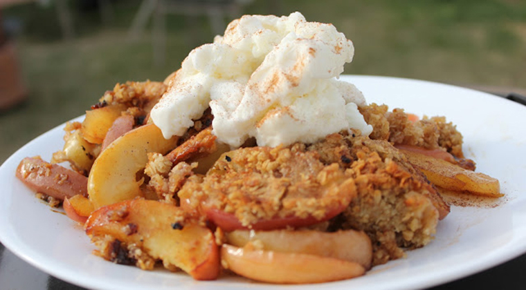 Apple crumble on a plate with cream on top