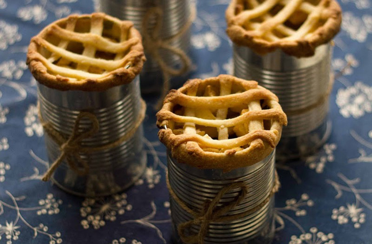 Apple pies in cans on a blue cloth