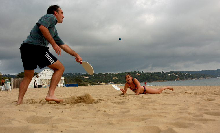 Couple playing bat and ball on the beach