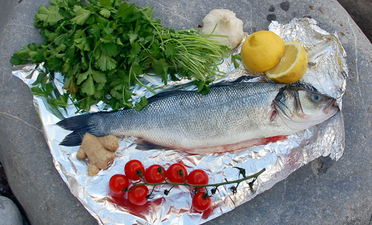 Gutted fish on foil with ingredients
