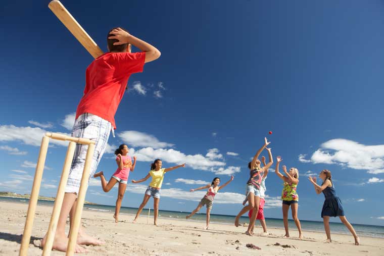 Kids playing cricket at the beach