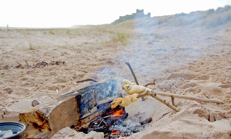 Bannock bread cooking on a fire on the beach