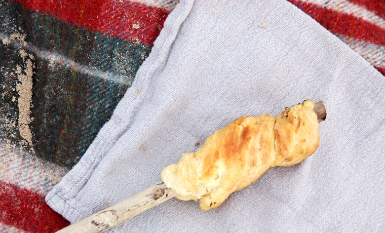 Bannock bread on a stick on a napkin