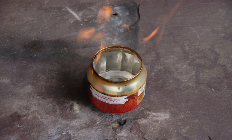 A burning soda can stove
