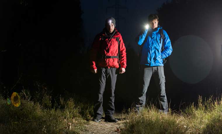 Men with torches hiking at night