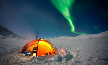 Cold weather tents in the snow with northern lights