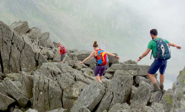Hikers carrying daypacks on rocks