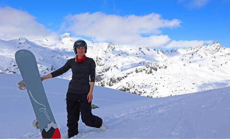Woman wearing base layer holding snowboard