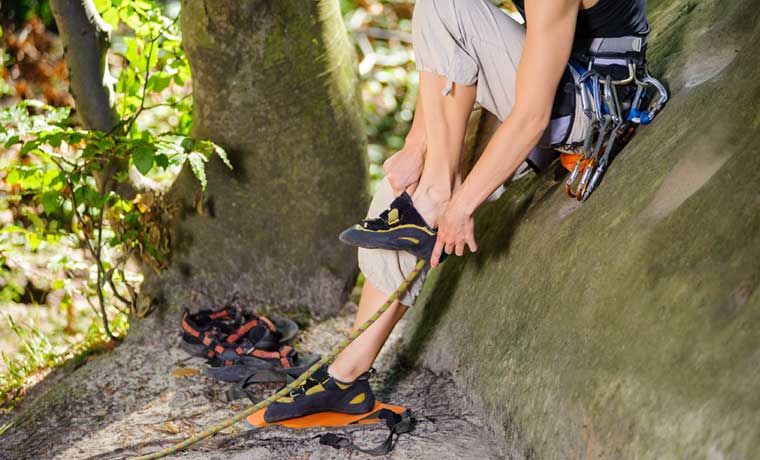Woman putting on the best climbing shoes