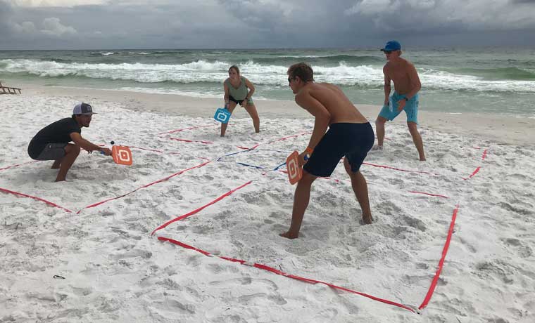 People playing Quaddlball on the beach
