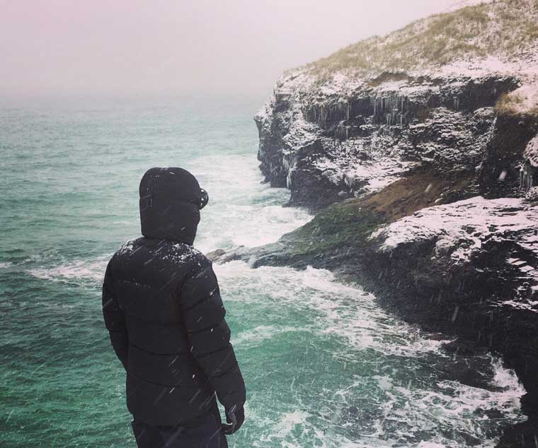 Standing on cliffs in snowy conditions