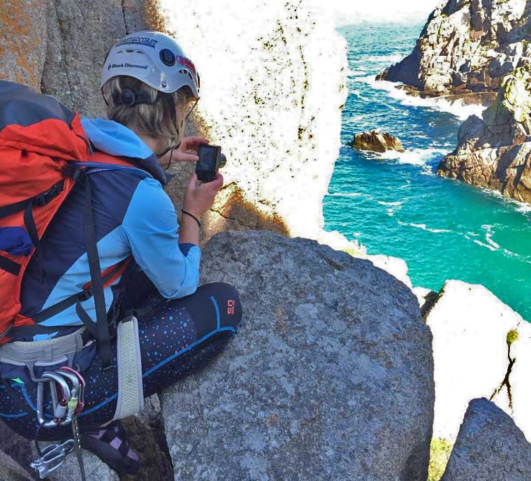 Climber in leggings taking a photo of the sea
