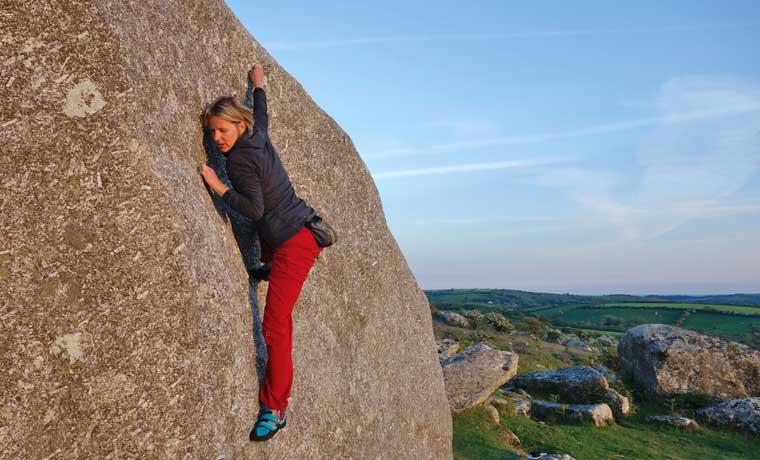 Woman bouldering in red climbing pants