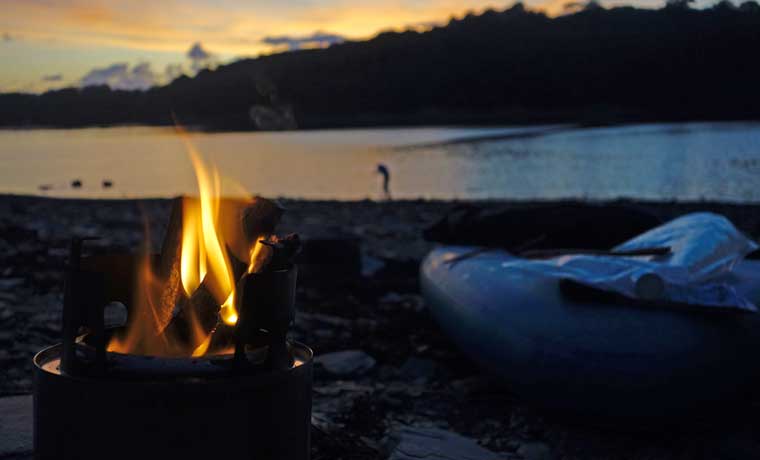 Campfire and sunset by river