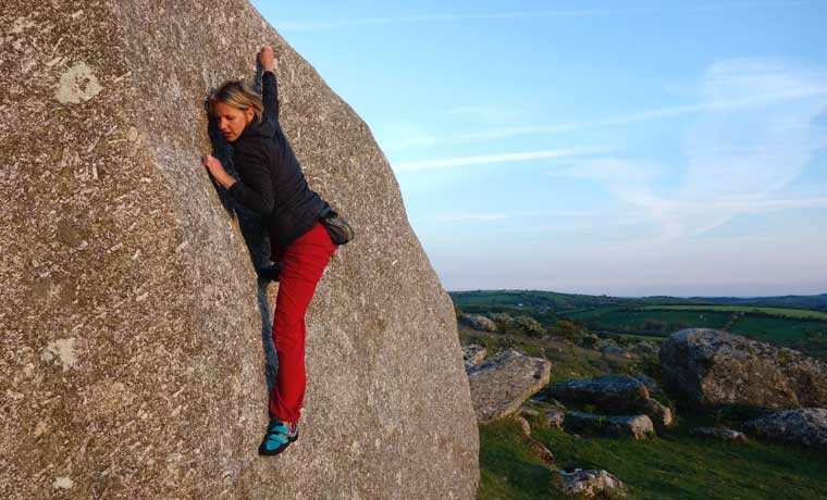 Woman climbing on boulder
