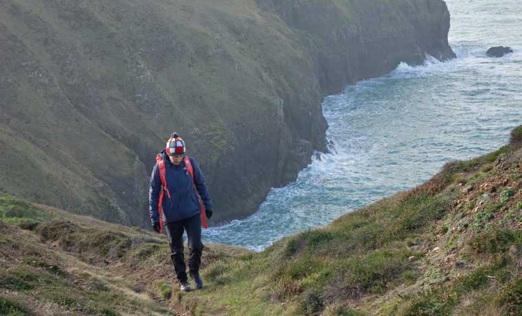 Woman walking on cliff edge