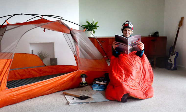 Woman reading next to tent in lounge