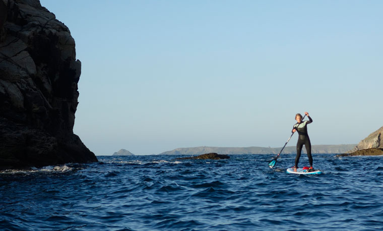 Paddle boarder and rocks