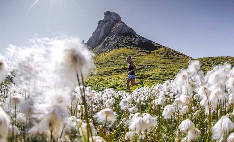 Woman running in mountain meadow