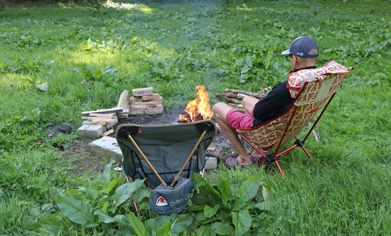 Man sitting by fire on camping chair
