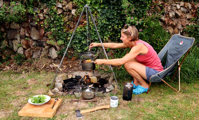 Woman cooking over campfire
