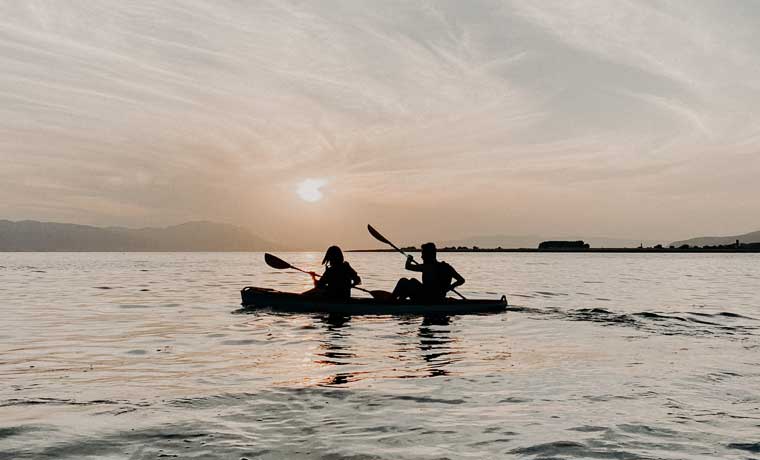 People in kayak at sunset