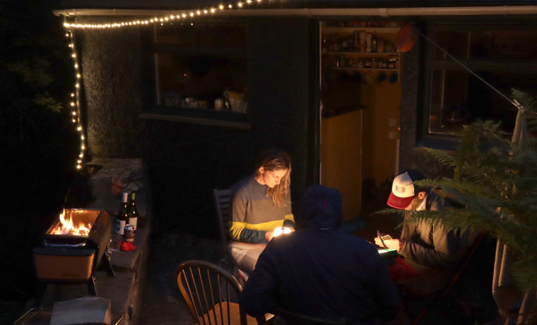 People playing cards by lantern light