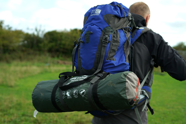 Man carrying tent in backpack