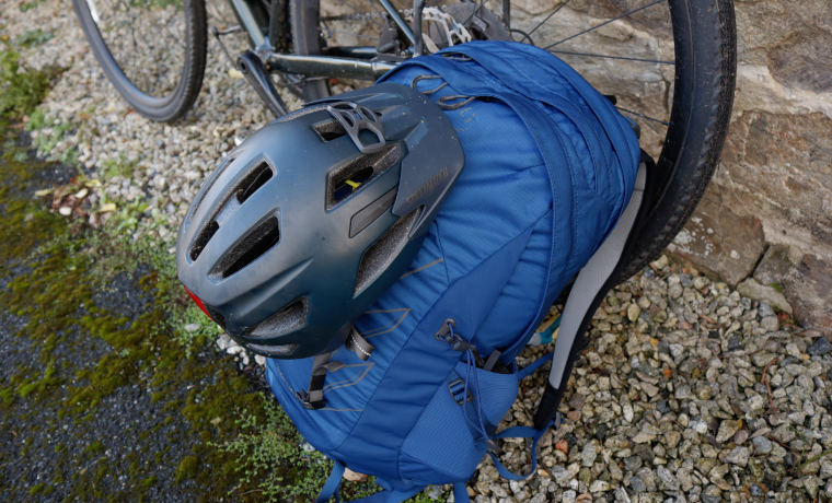Helmet on backpack next to bike
