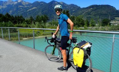 Cycle touring man on bridge with bike
