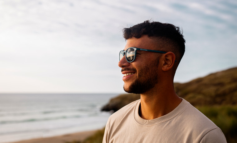 Man wearing sunglasses next to the sea