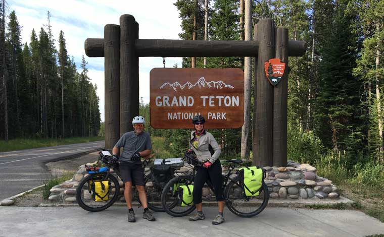 Bikepackers next to Grand Teton Sign