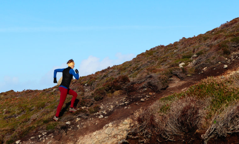 Woman running up a steep trail