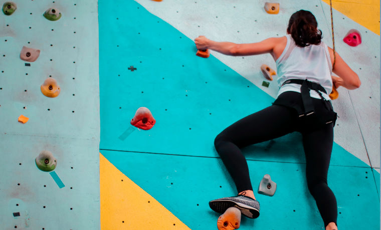Woman rock climbing indoors