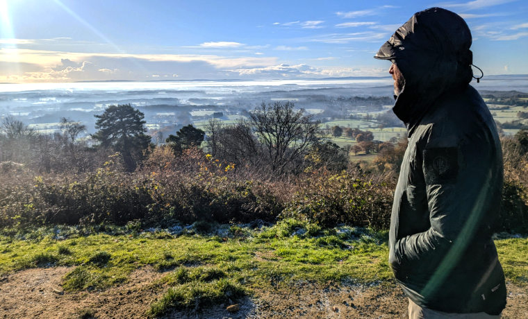 Man standing looking over frosty valley