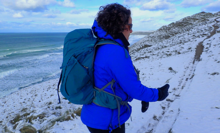 Woman hiking in the snow by the sea