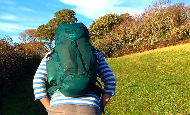 Woman hiking with green Rab daypack