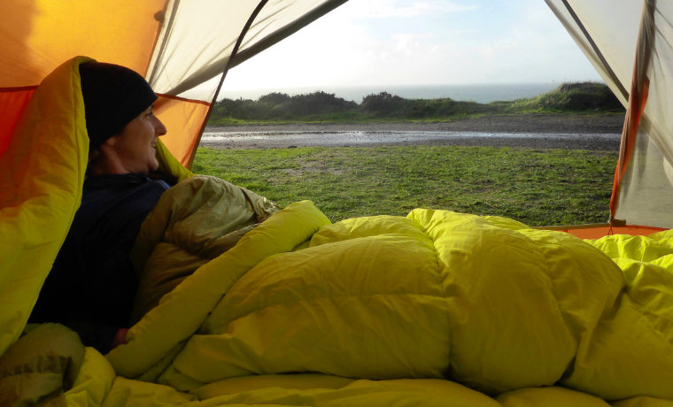 Woman in sleeping bag in tent