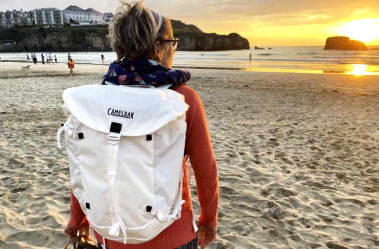 Woman on beach with backpack